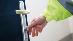 A professional inspecting a Gerda double fire door set in a residential building.