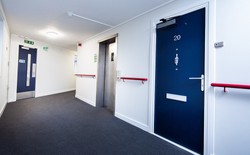 Residential corridor with Gerda multiperformance flat entrance doorsets providing fire safety and modern aesthetics.